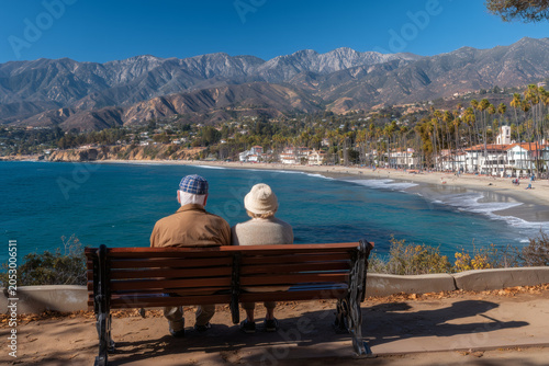 Ancianos sentados en un banco mirando el paisaje