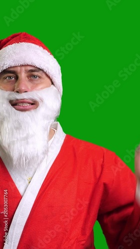 Santa Claus in red suit wag hand palm on green chroma key background. Christmas and New Year celebration concept. Vertical footage
