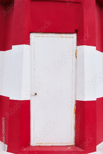 détail de la façade d'un phare en béton rouge et blanc