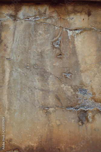détail de texture sur un mur décrépi ocre et marron de la façade d'une vieille maison en béton 