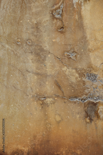 détail de texture sur un mur décrépi ocre et marron de la façade d'une vieille maison en béton 