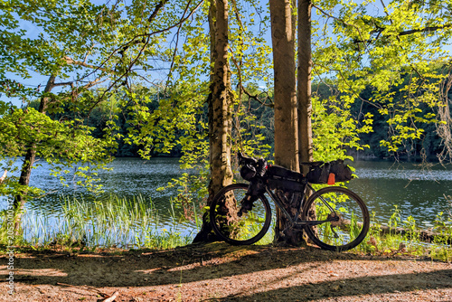 Loaded gravel bicycle on the background of the wild lake
