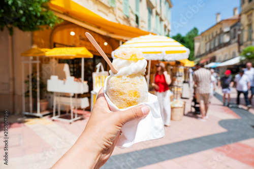 Canvastavla Close-up of a refreshing lemon sorbet ice cream being held in hand on a sunny street in Menton, French Riviera