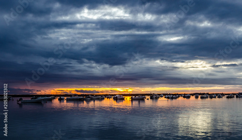 Cuadro en lienzo Coucher de soleil dramatique sur un plan d’eau calme sous ciel nuageux