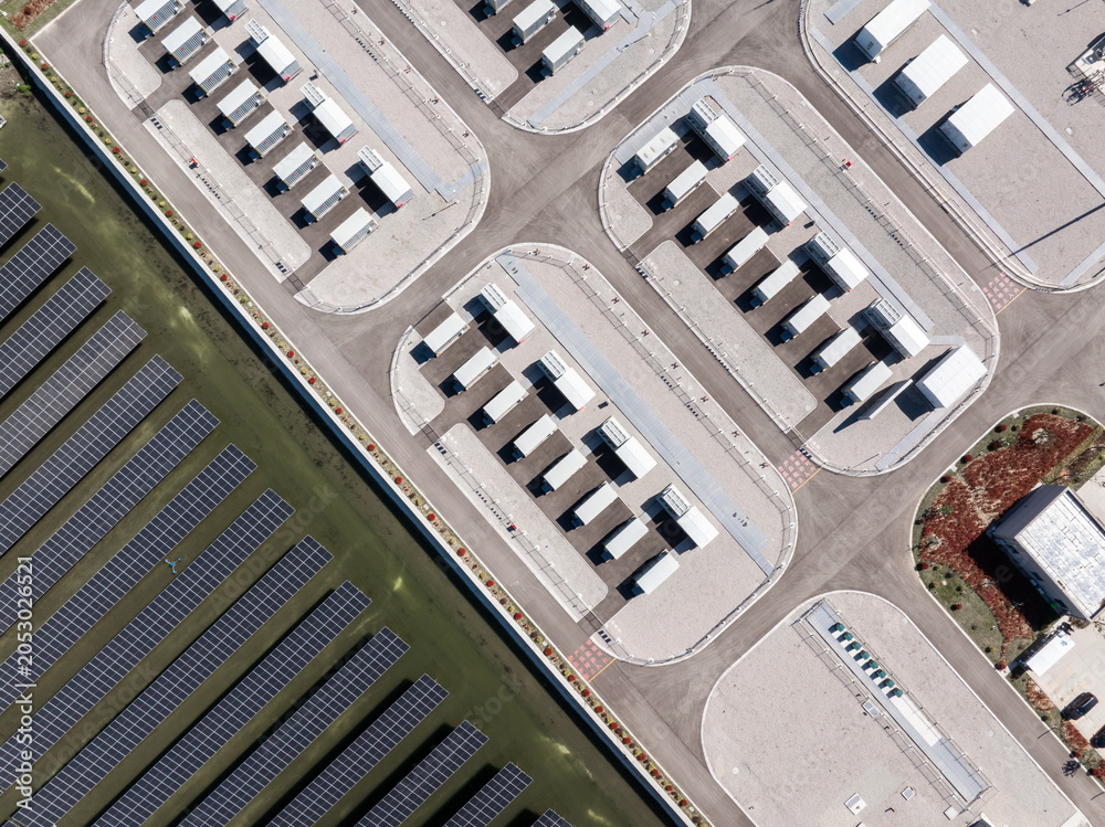 Naklejka premium Aerial view of solar power plant and data center facilities with rows of photovoltaic panels