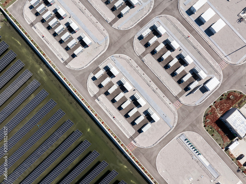 Aerial view of solar power plant and data center facilities with rows of photovoltaic panels