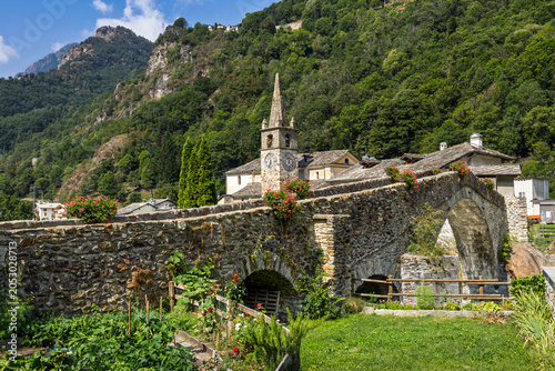 Medieval stone bridge and church in Lillianes, Aosta Valley, Italy