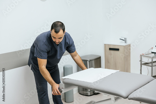 Physiotherapist preparing treatment table in rehabilitation clinic