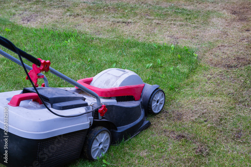 Φωτογραφία a lawn mower in the process of cutting grass, showing a clear distinction between the tall and mowed areas