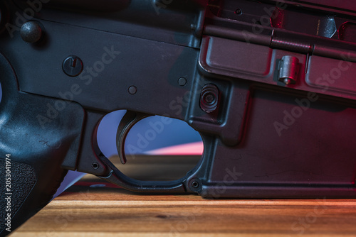Close Up of Rifle Trigger and Lower Receiver on Modern Sporting Firearm Under Cinematic Neon Lighting, Technical Weapon Detail and Safety Concept