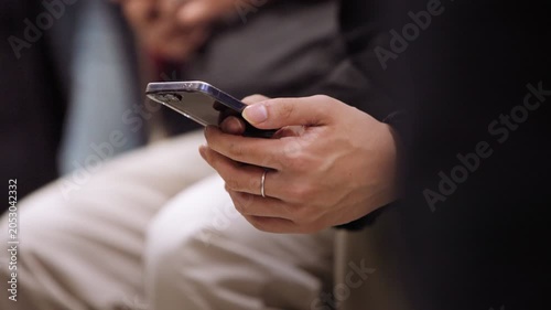 Slow motion close view of an unrecognizable Taiwanese woman using a smartphone inside the metro, showing daily commuting, public transportation, technology and urban life