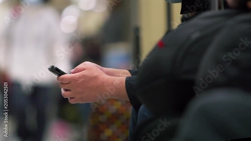 Slow motion close view of an unrecognizable Taiwanese commuter using a smartphone inside the metro, showing public transportation, daily travel, communication and urban lifestyle
