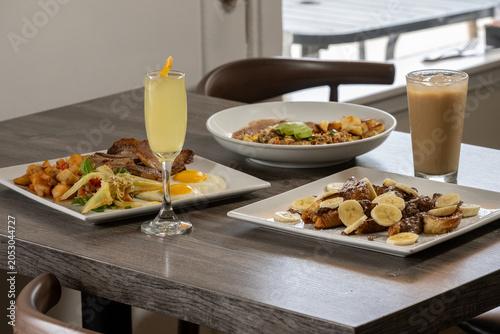 Foto Breakfast feast set up on the table with french toast, mimosa, iced coffee, and
