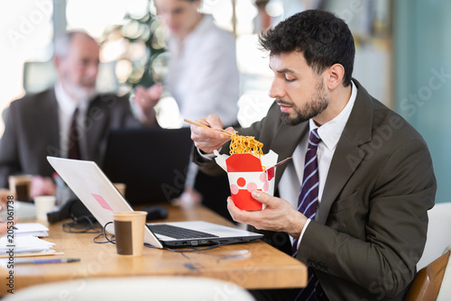 Tablou pe pânză Office staff are indignant because of unpleasant smell of food and resent for eating male colleague