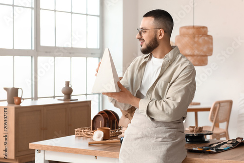 Young male sculptor with pl...