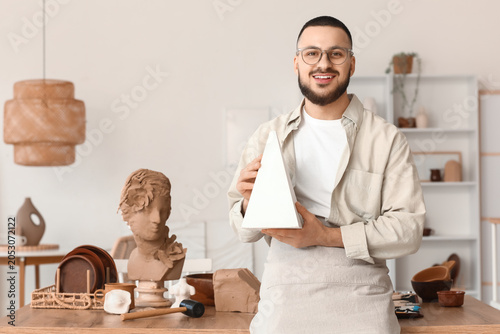 Young male sculptor with pl...