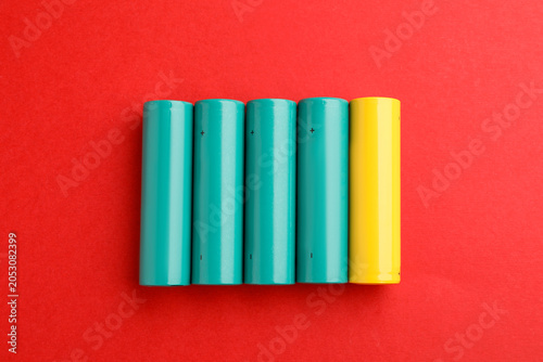 Photos Many alkaline batteries on red background, flat lay