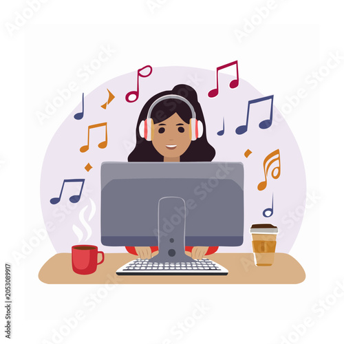 Woman with headphones working on computer and listening to music