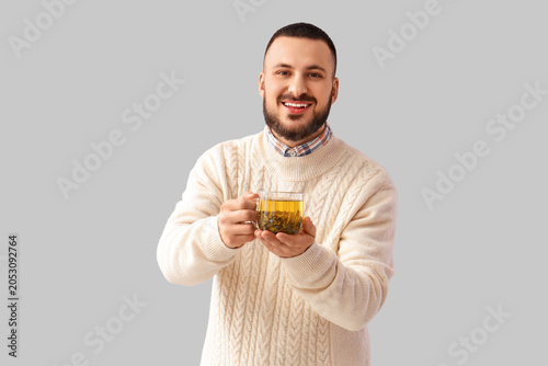 Young man with glass cup of...