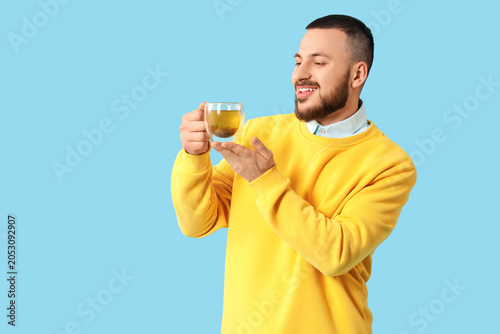 Young man with glass cup of...