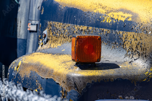 Quadro su tela Quebec, Canada, 27 April 2026 : A close-up view of a weathered vehicle's turn signal and peeling yellow and black paint