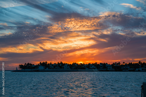 Fotografie Colorful cloud formations cover the evening sky over the dark Key West island silhouette during the summer sunset transition