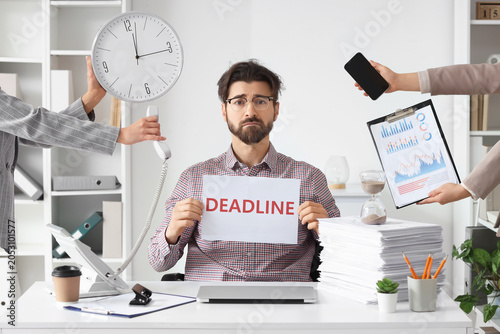 Billede på lærred Overwhelmed businessman holding deadline sign with multiple hands offering tasks