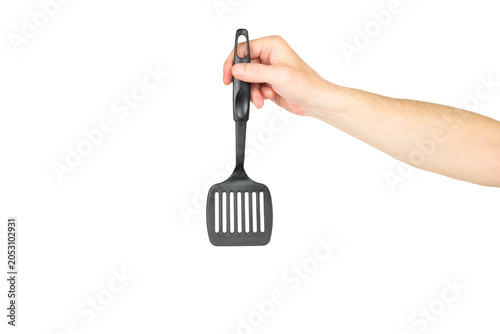 person holds a black plastic slotted kitchen spatula vertically on a white background