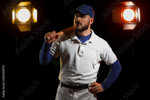 Fotografie Confident baseball player in uniform holding bat over shoulder, studio lighting,