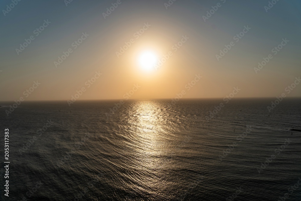 Obraz premium Sunset Over the Ocean With Bright Sun Reflecting on Water’s Surface During Evening Hours