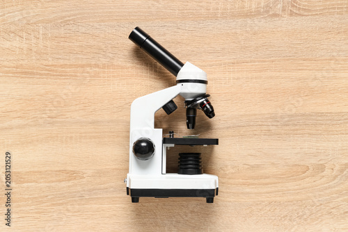 Modern microscope on wooden background