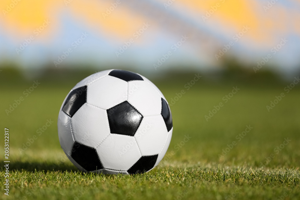 Fototapeta premium Soccer ball on green stadium grass, closeup