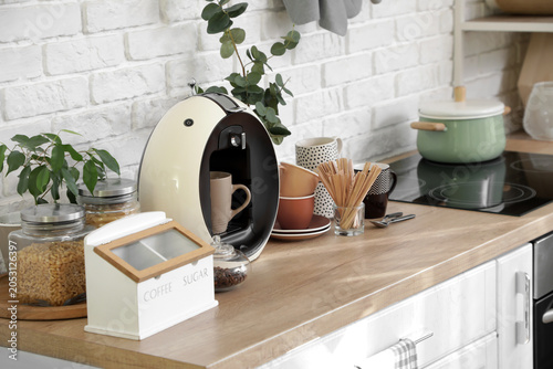 Bild auf Leinwand Modern coffee machine, sugar bowl, stirrers and cups on table in kitchen
