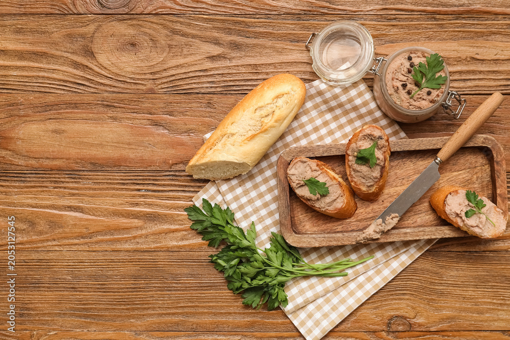 Fototapeta premium Jar of tasty pate with toasts, parsley and knife on wooden background