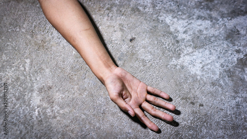 Konstfotografi A crime scene concept showing a human hand lying lifeless  or dead body on the concrete floor, with the body covered by a white cloth fabric