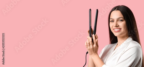 Smiling woman holding hair ...