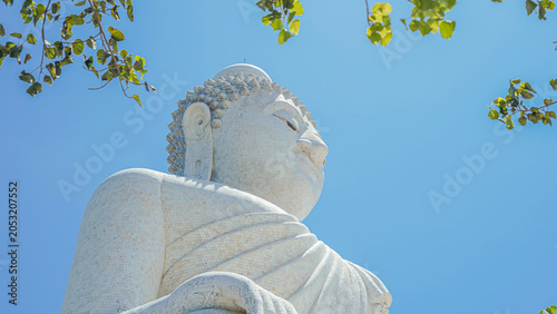 Phuket Big Buddha statue. afternoon light sky and blue ocean are on the back of white Phuket big Buddha is the one of landmarks on Phuket island Thailand.
