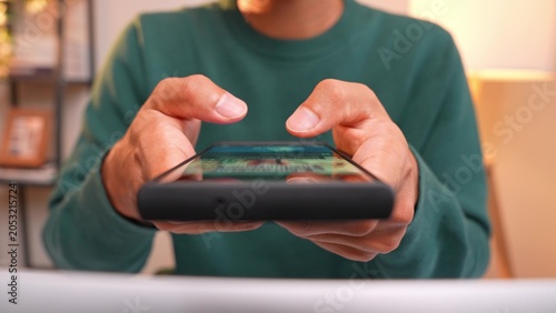 Photos A salaried employee aimlessly scrolls through their smartphone, unable to concentrate on work