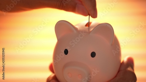 Bilde på lerret A salaried employee drops a coin into a piggy bank under warm sunlight, symbolizing saving habits, financial planning, discipline, future security, and the importance of building wealth step by step