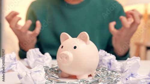 Quadro su tela An employee displays tense, depressed body language due to financial struggles, surrounded by crumpled bills and a chained piggy bank, symbolizing the stress and emotional weight of money problems
