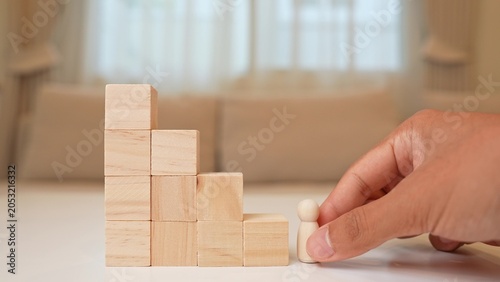 Bild auf Leinwand A wooden figure stands at the base of descending block steps, symbolizing stagnation, career decline, lost momentum, challenges in progress, resilience, and the importance of adapting to change