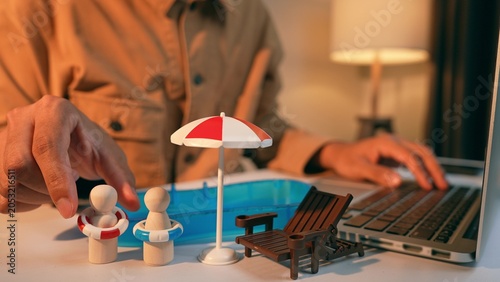 Fotografia A freelancer places swim rings on wooden figures surrounded by holiday toys, symbolizing thoughtful holiday planning the importance of balancing work responsibilities with meaningful relaxation time