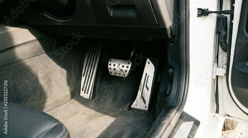 Modern luxury car footwell interior with metal pedals.