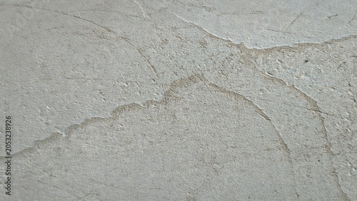 Rough textured stucco wall surface creating an abstract gray background pattern