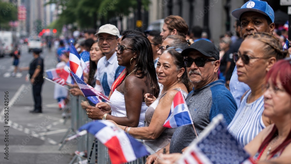 Obraz premium People celebrate on the street holding flags during a parade in a city on a sunny day in summer