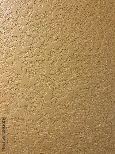 Detailed Close-up of Knockdown Drywall Texture for Renovations. Yellow Wall to Use as Background with Knockdown Finish. Cream texture wall background.