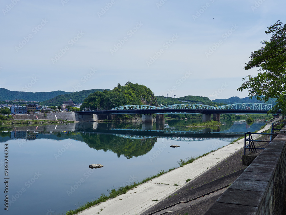 Obraz premium 初夏の朝の観光地犬山市の木曽川遊歩道から見た木曽川と沿岸の風景