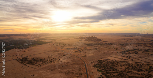 Aerial view of the sunrise over the sandstone rock formations in the ancient site of Hegra, AlUla