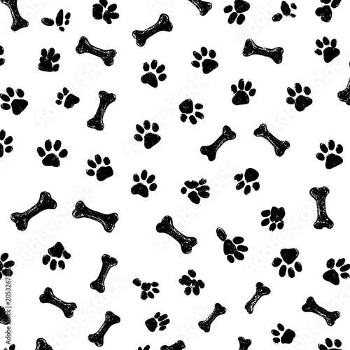 Seamless black and white pattern of dog paw prints and bones with a playful grunge texture