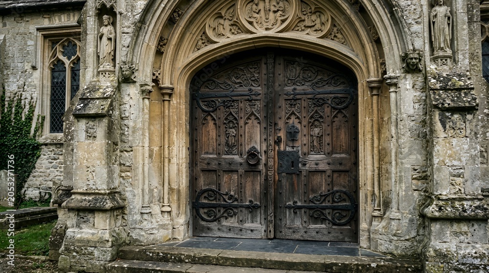 Fototapeta premium Ancient arched wooden door of a historic stone church building with historic architecture entrance medieval cathedral heritage building structure exterior religion tradition religious